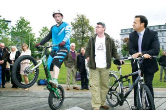 Minister for Transport, Tourism and Sport Leo Varadkar with Shane Foran of the Galway Cycling Campaign watch Scott Coyne of MBW Moycullen perform bike tricks at the launch of Galway Bike Festival in Eyre Square on Friday.  Photo:-Mike Shaughnessy