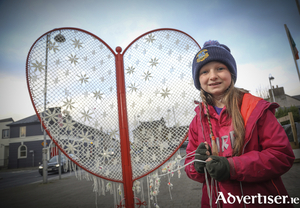 Headford&rsquo;s youngest lacemaker, Gr&aacute;inne N&iacute; Bhroin, with the Lace Matrix sculpture in St George&#039;s Square, Headford. Photos by Aengus McMahon
