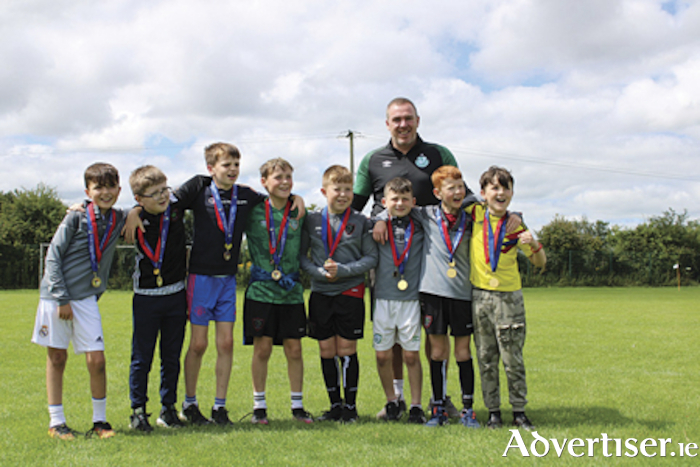 Members of the Willow Park Under 10 team who won the league and cup double last year are pictured receiving their medals from former Republic of Ireland international, Richard Dunne, during the family fun day on Sunday