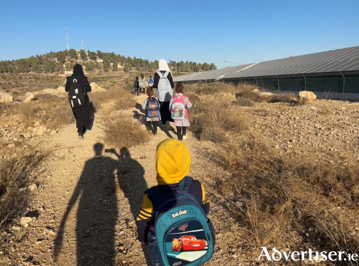 Palestinian children on their way to school close to an Israeli settlement on 26 September, with the shadows of EAs who provide a protective presence in the face of settler harassment. 