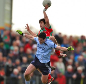 Pat Harte fly's high to win the ball against Ross McConnell in Ballina on Sunday. Photo: Sportsfile.