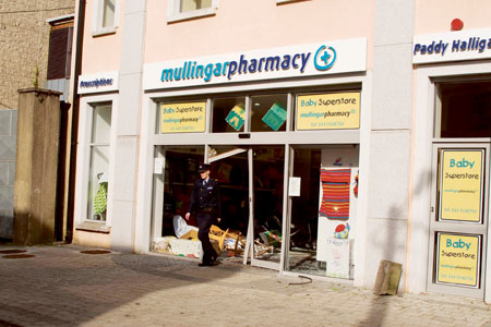 A Garda stands outside Mullingar Pharmacy yesterday (Thursday), following an incident in which four men rammed a car into the premises early yesterday morning. See page 2. 
Photo: Thomas Gibbons.
