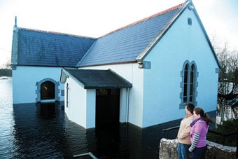 The Lord works in mysterious ways — Locals view the flooding at Kiltartan Church on Wednesday. Photo:- Mike Shaughnessy
