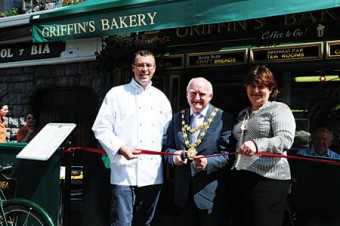 Jimmy Griffin of Griffins Bakery/Bácús Uí Ghríofa, Councilor Declan McDonnell, Mayor of Galway City, unveiling the new bilingual shop front of Griffins Bakery, and Bríd Ní Chonghóile, of Gaillimh le Gaeilge the organisation responsible for promoting the use of the Irish language in Galway city.