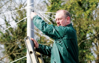 Cllr Billy Cameron pictured tackling the unsightly poster ties.