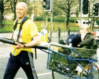 Picture of Robin Hood towing his late daughter Alex in a converted shopping trolley in the 2001 London Marathon. He raised £13,000 for the charity Debra which provides patient support services and funds research into treatment and cures for those living with the genetic skin condition epidermolysis bullosa (EB).
