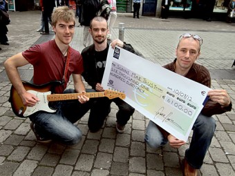Busker Jamie Harrison of Maree with the cheque for €6,000 which was presented to Paul Hayes and Leighton Morrison of the Sunni Mae Trust.  Leighton is the father of four-year-old  Lily Mae  Morrison who was recently diagnosed with Stage 4 neuroblastoma, a rare form of cancer that affects one in every 100,000 children in Ireland. Photo:-Mike Shaughnessy