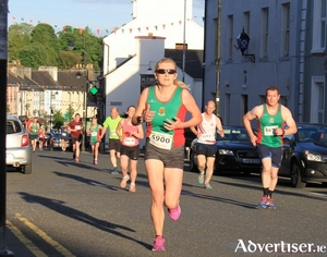 Angela McVann (Mayo AC)  leads a group along Upper Main St at the Ballyhaunis 5km on Tuesday evening. 