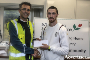  Naoise O Gibne of GCH, winner of the Corrib AC 8km, receives first prize from John O&#039;Sullivan of the Galway Wind Park.              Photo: John O&rsquo;Connor
