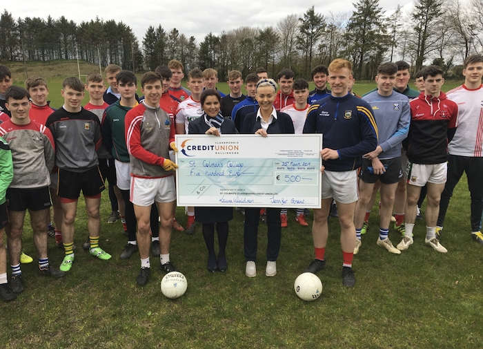Sinead Stagg and Laura Waldron of St Colman's Credit Union handing over a sponsorship cheque of €500 to Enda Hession (Captain), Cillian Golding (Vice-Captain) and the St Colman's senior football team. 