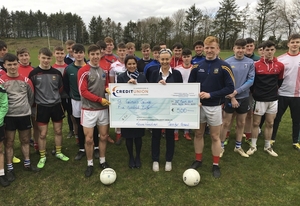 Sinead Stagg and Laura Waldron of St Colman&#039;s Credit Union handing over a sponsorship cheque of &euro;500 to Enda Hession (Captain), Cillian Golding (Vice-Captain) and the St Colman&#039;s senior football team. 