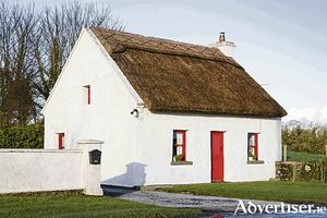 A typical Irish thatched cottage, near the village of Cong, straddling the borders of County Galway and County Mayo.