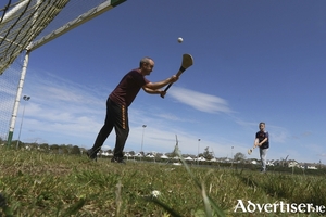 Twelve-years-old Dylan Gaughan of Liam Mellows Hurling Club has a puck around with his Dad Brian on Wednesday ahead of the lifting of Covid 19 restrictions.  Photo:-Mike Shaughnessy