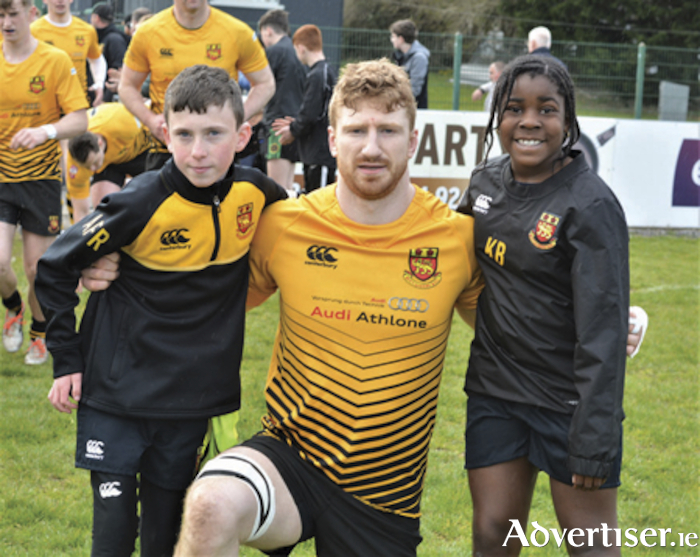 Buccaneers captain, Evan Galvin, is pictured with team mascots, Koko Massey and Archie Farrell-Rooney following the club’s victory over Ballymena in Dubarry Park on Saturday.
