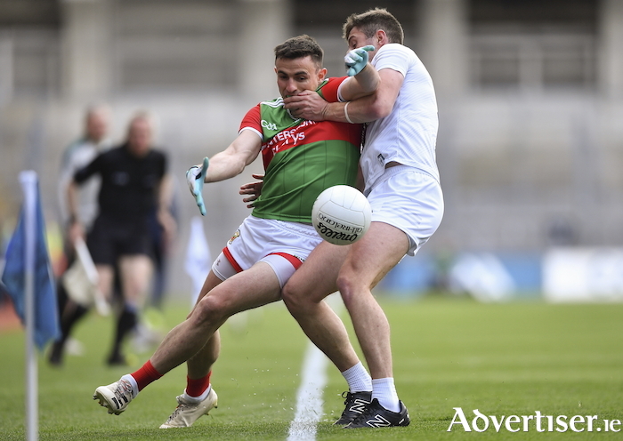 Eyes on it: Jason Doherty keeps his eye on the ball despite the close contact from Kildare's Shea Ryan. Photo: Sportsfile. 