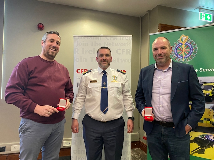 Here to help: Thomas White and (right) Ken Seymour accepting certificates and medals on behalf of Westport CFR from Ger O'Dea NAS for operating during the Covid 19 pandemic. Photo: National Ambulance Service.