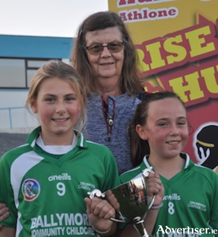 Vera Corcoran presents the Corcoran Cup to Eliza Mallon and Eva Hickey, joint captains of Drumraney Under 9 camogie team.