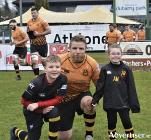 Buccaneers captain, Martin Staunton, is pictured with matchday mascots, Campbell Walkinson and Aoife Nolan, prior to the Pirates victory over St Mary&rsquo;s College at the weekend

