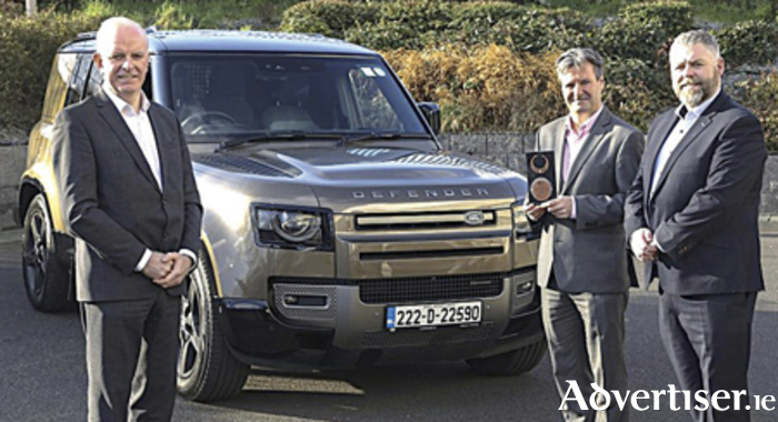 Tom Dennigan of Continental Tyres and Joe Rayfus, Chairman of the MMAI, present Eddie Kavanagh of Land Rover Ireland (centre) with the trophy for Commercial SUV of the Year 2023, in front of the winning vehicle, the Land Rover Defender Commercial. 