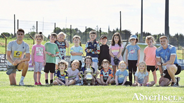 Robbie Forde, Athlone GAA’s Games Promotion Officer, and current senior footballer, Ray Connellan, are pictured with young players holding the Tailteann Cup during a summer camp at the club last year