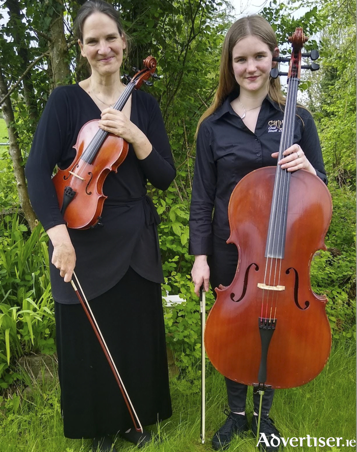 Katharina Baker (Coole Music & Arts Director) holding her viola and accompanied by her daughter Naima, who prepares to graduate this Sunday, May 14, at a Gala Concert in Lady Gregory Hotel, Gort as a cellist and Coole Harmonies Choir Member.