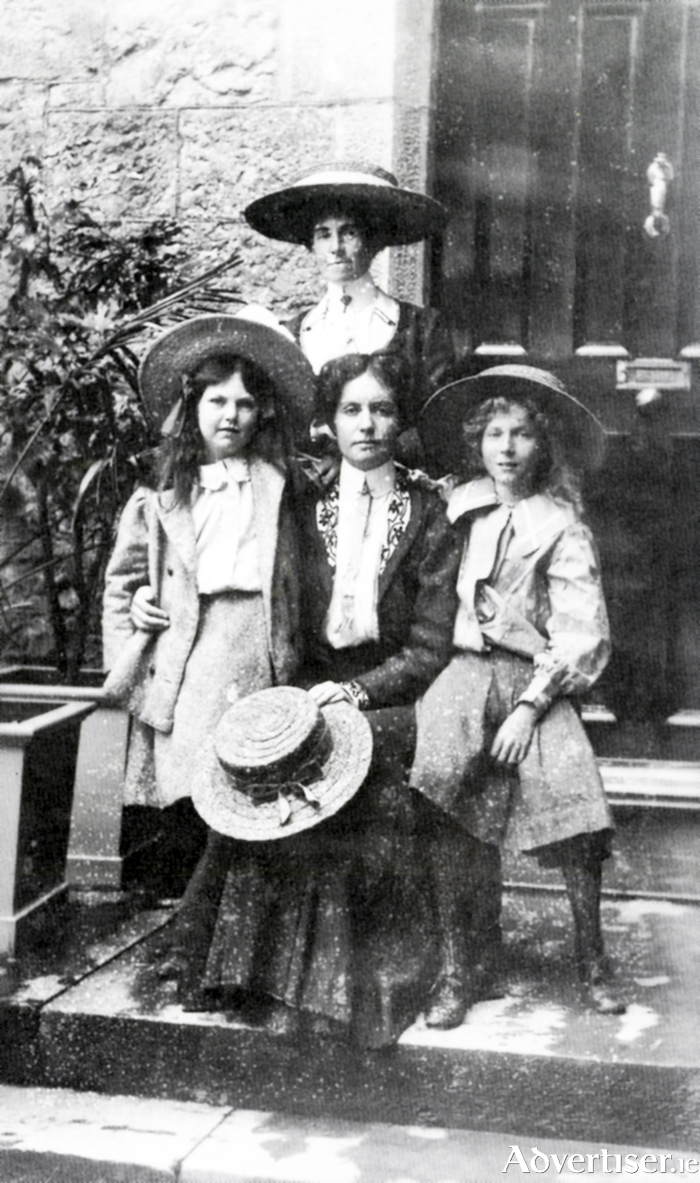 Emily’s mother Gertrude is seated with Emily standing on left, and her sister Elsie seated right. Standing behind is Elisa Curtet, the children’s Swiss governess. The photograph was taken outside their living quarters at University College Galway. 