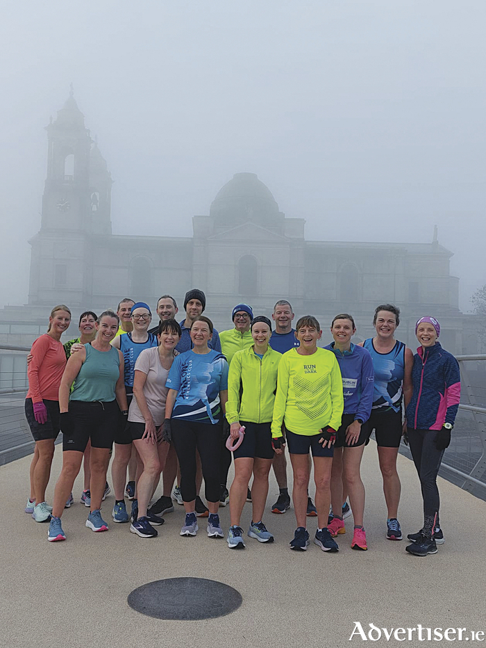 Athlone Athletic Club members take time out for a photograph on the cycleway bridge during their final training run before the Dublin City Marathon on Sunday