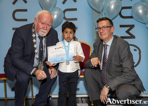 Darshan Jay receives a silver medal from Deputy Mayor Cllr Donal Lyons and Mr Terry Kelly, senior manager Kumon Europe and Africa, at the Kumon awards ceremony. 
Photo: Murt Fahy.