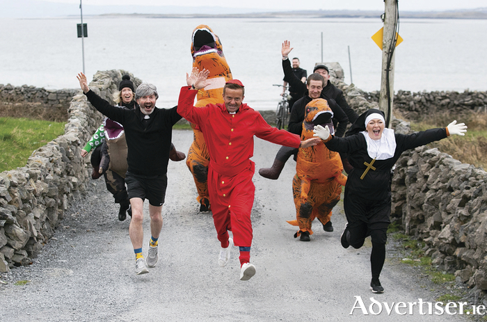Martin Boyle from  Glasgow, Michael Mee from Yorkshire, Joanne Gorman from Finglas pictured at TedFest earlier this year at Inis Mór on the Aran Islands being chased by Dinosaurs.  Tickets are now available for TedFest 2024  which takes place on Thursday March 7th to Sunday March 10th 2024 as Inis Mór in the Aran Islands becomes the legendary ‘Craggy Island’ once more for a weekend of high-jinx.  Copious cups of tea and sandwiches, a lot of red tank-tops, nuns on the run, priests on the pull, map-cap costumes and of course a bishop getting a kick up the arse -  Fr Ted, Ireland’s best loved TV Show is celebrated. See www.tedfest.org for tickets. Careful now!  Photo: Gareth Chaney