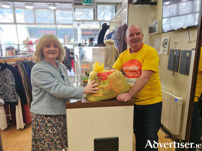 “Enable Ireland volunteer, Ken, accepting a bag of pre-loved items donated as part of Enable Ireland’s ‘Break Up With Your Stuff’ Campaign”