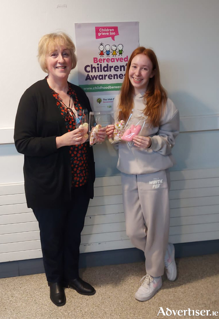 Vivian Roche-Fahy, bereavement liaison officer at UHG, receiving the knitted hearts from Pippa Lyons.