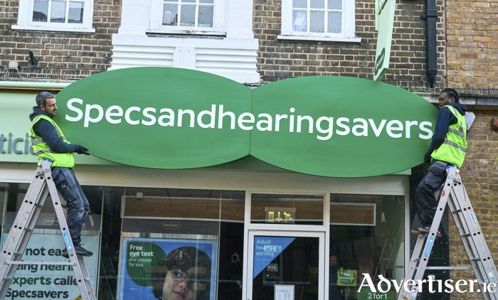 Specsavers highlights its expertise in hearing services as builders attempt to fit new store logo.