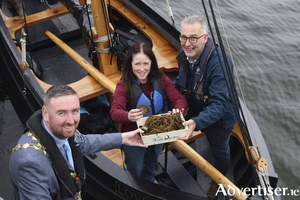 Mayor Mike Cubbard accepting the first oyster of the season, on Tuesday, from oyster farmer Duirmuid Kelly, and Colette Furey of Galway Hooker Sailing Club.