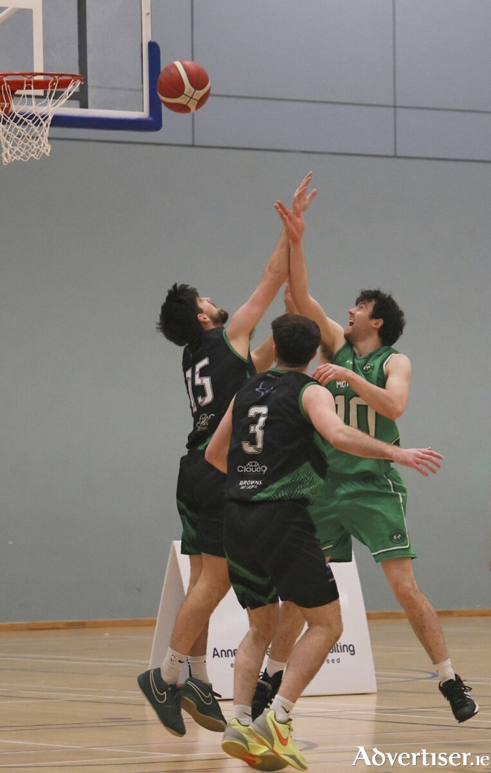 John Hackett of Mhaigh Cuilinn shoots above Kyle Burke and Michael Wallace of Portlaoise Panters in action from the Basketball Ireland Domino&rsquo;s Division 1 National League game at the Kingfisher Sports Centre. (Photo: Mike Shaughnessy)