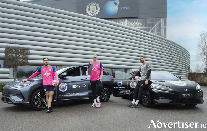 Manchester City footballers Rayan Cherki, Erling Haaland, and Gianluigi Donnarumma pictured with vehicles from the club's new official automobile partner, BYD.