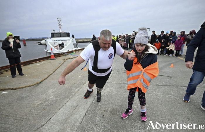 Paralympian and amputee Shane Mc Loughlin successfully pulled the 120 tonne Aran Island Ferries&rsquo; vessel, Saoirse na Farraige, 5 metres. Pictured with Shane after crossing the 5 metre line is 7 year old Katie Walsh from Tuam, who is also an amputee. Photo: Ray Ryan.