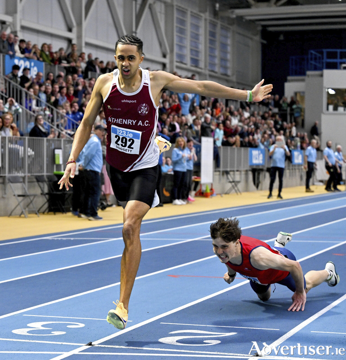 Sean Doggett of Athenry AC, on his way to winning the men's 400m over as Fintan Dewhirst of T&iacute;r Chonaill AC, Donegal, falls during the National Senior Indoor Championships. (Photo by Sam Barnes/Sportsfile)