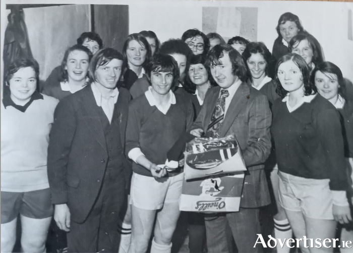 Galway businessman Joe Hanley presenting a set of socks to the first Galway senior ladies football squad to reach an All-Ireland Final in 1975. Receiving the socks on behalf of the team and squad is Galway captain Rosemary Divilly. Also pictured to her right is Frank Kearney, who was key in promoting the game in Galway.