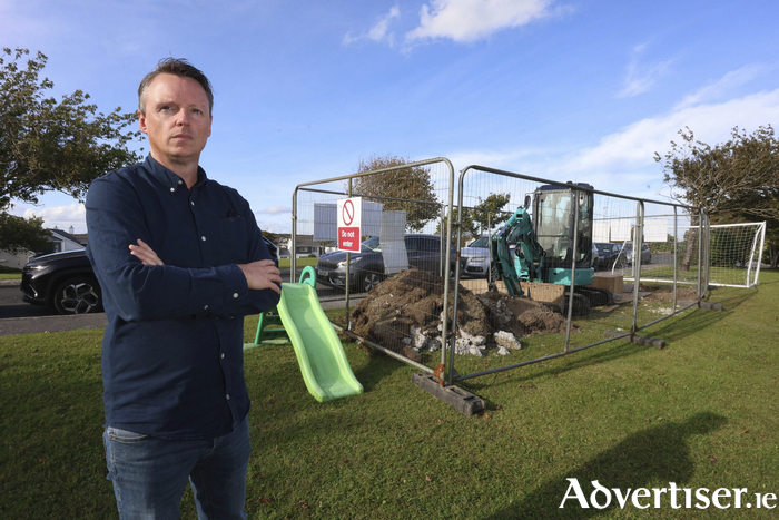 David Hannon at site of proposed 5G mast in Carragh Hill with cars parked along roadway behind it. Photo: Mike Shaughnessy